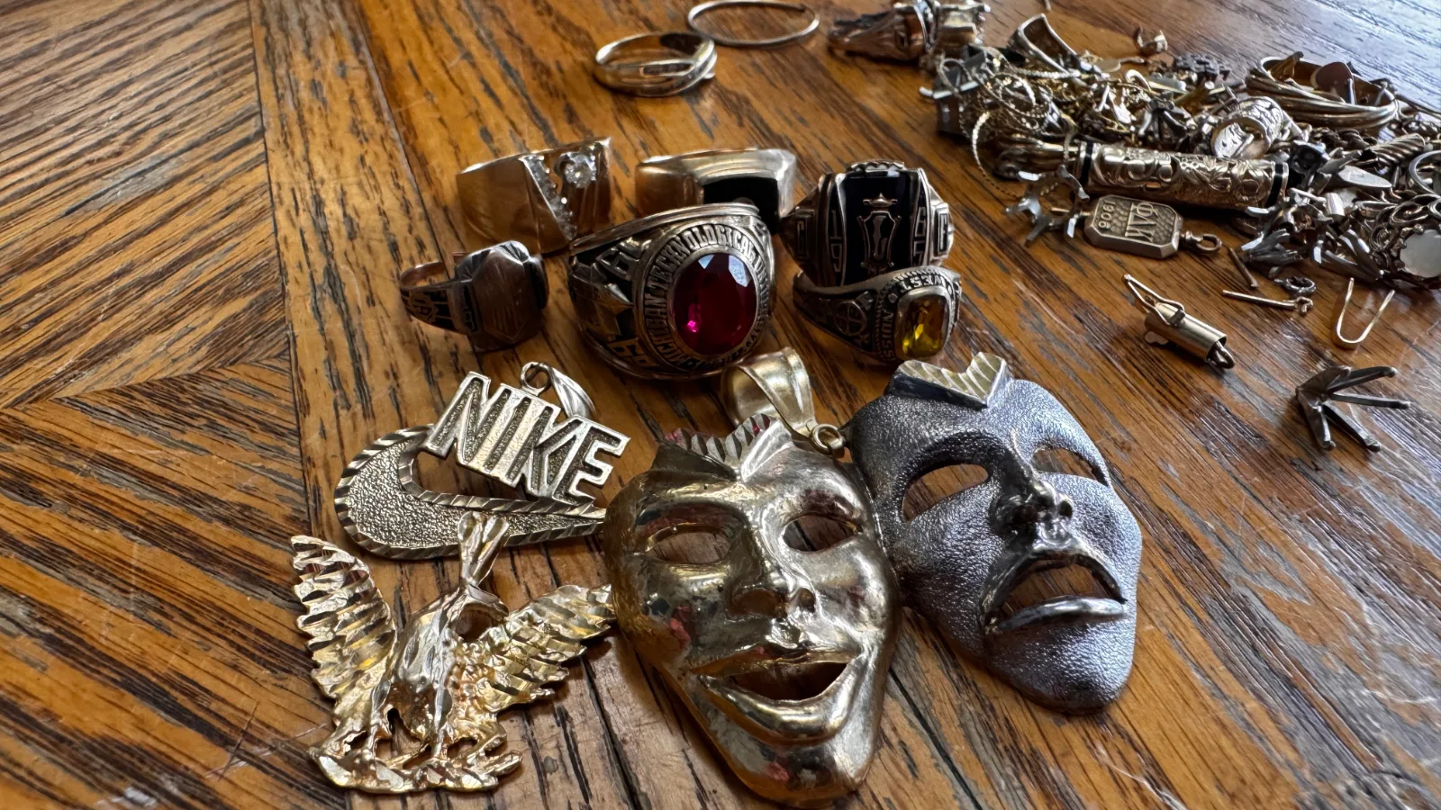 various gold and silver rings pendants and jewelry on wooden table