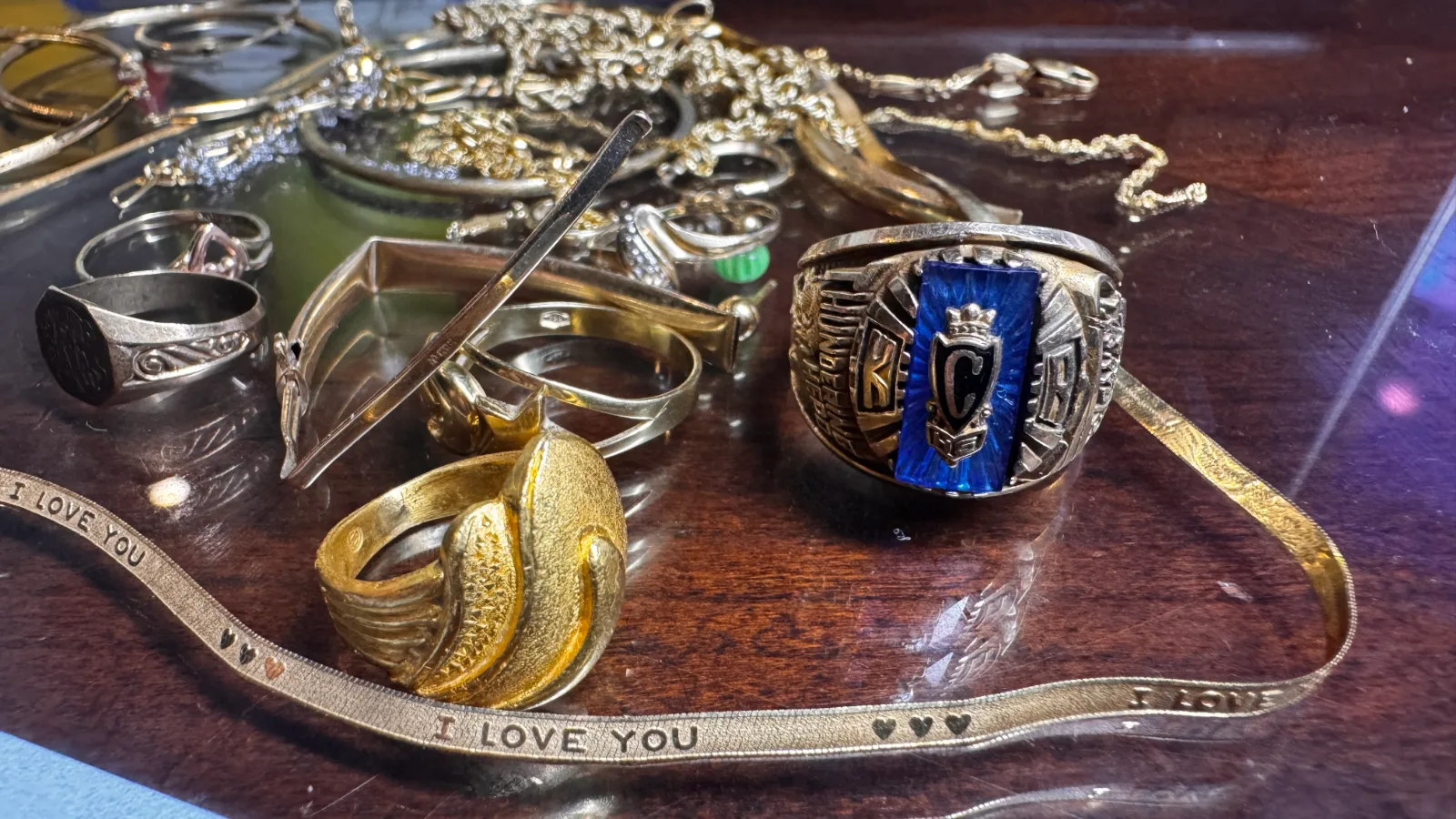 collection of gold and silver rings and chains on wooden surface
