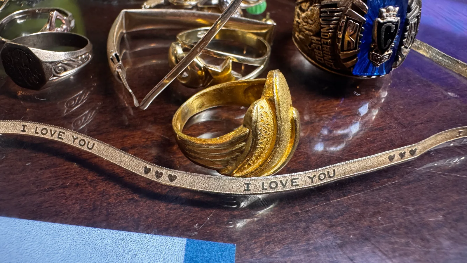 various gold and silver rings and a bracelet engraved with i love you