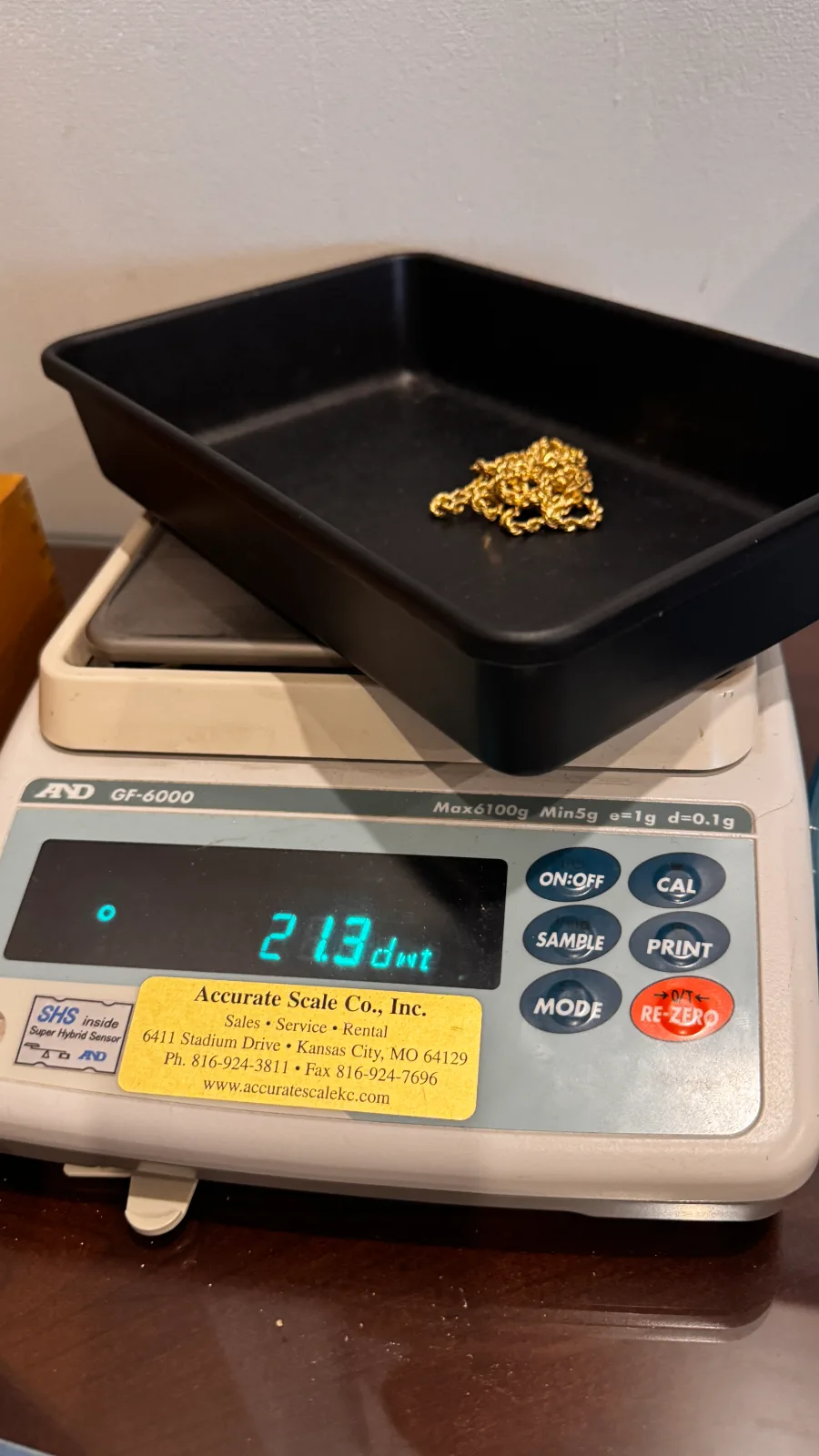 gold chain in a black tray on a digital weighing scale