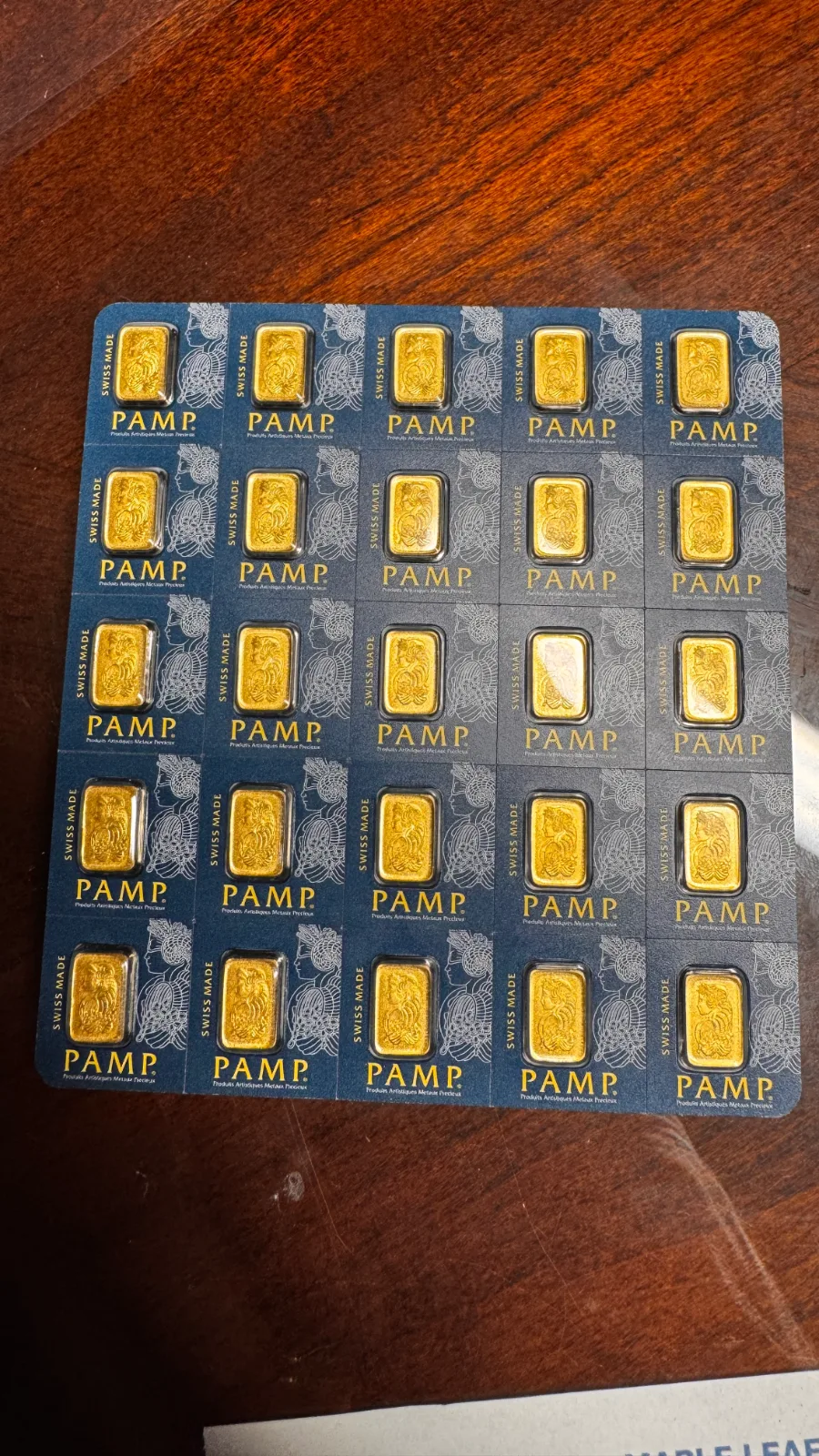 grid of twenty-five small gold bars in blue pamp suisse packaging