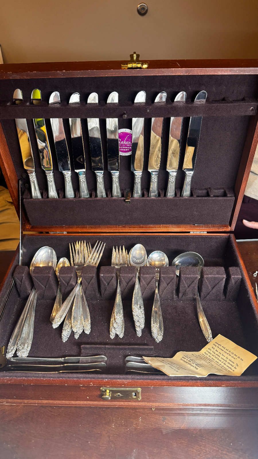 open wooden chest containing a set of silver knives forks and spoons