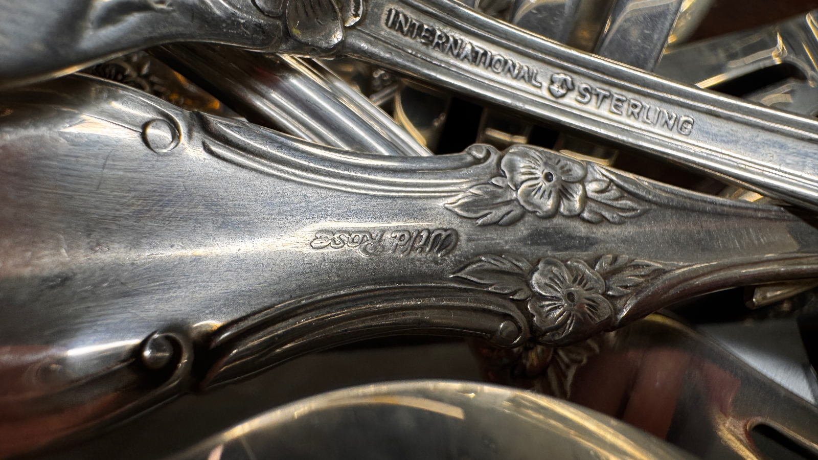Close up of sterling silver cutlery handle with floral engravings and hallmarks